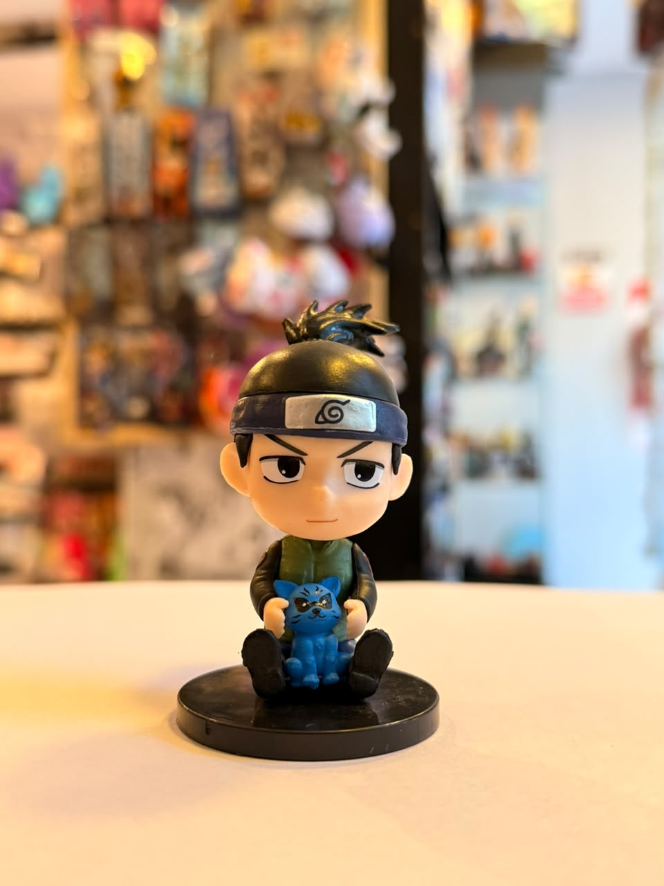 FIGURA GASHAPON DE IRUKA SENTADO JUNTO A CRIATURA AZUL