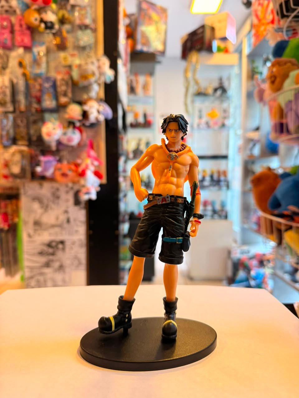 FIGURA DE ACE SIN CAMISA EN POSTURA RELAJADA CON UNA MANO APOYADA EN LA CADERA
