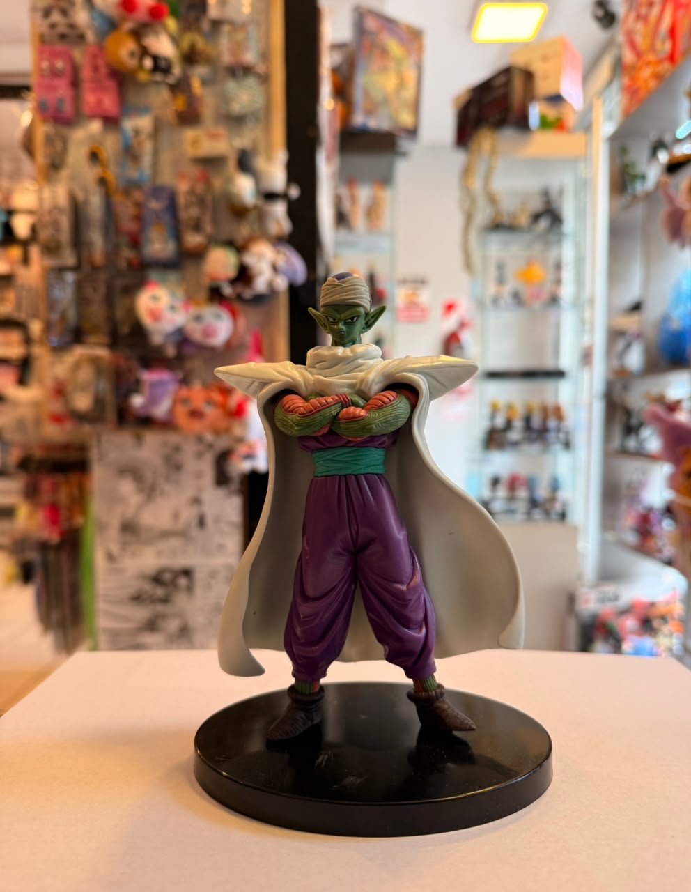 FIGURA DE PICCOLO CON SU CAPA BLANCA Y BRAZOS CRUZADOS