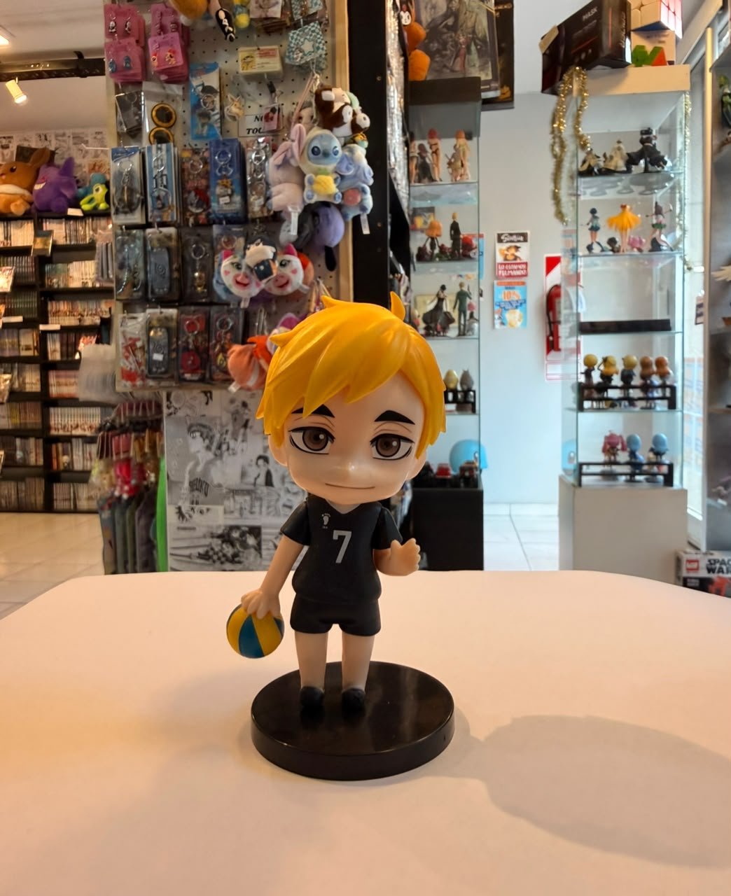 FIGURA CHIBI DE ATSUMU MIYA CON SU UNIFORME NEGRO Y SOSTENIENDO BALON BAJO LA MANO