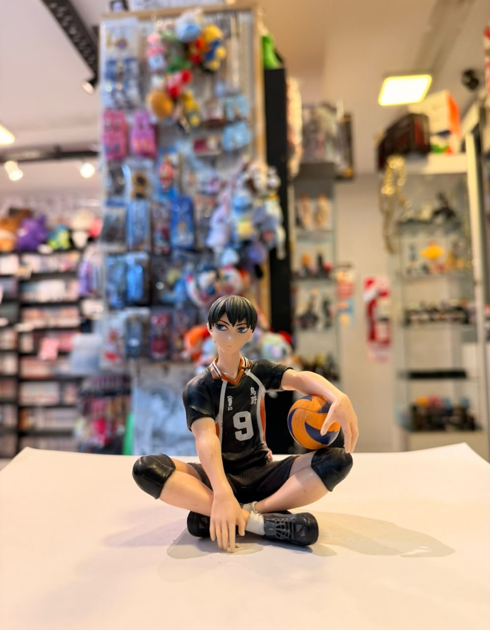 FIGURA DE TOBIO KAGEYAMA SENTADO SOSTENIENDO UN BALON