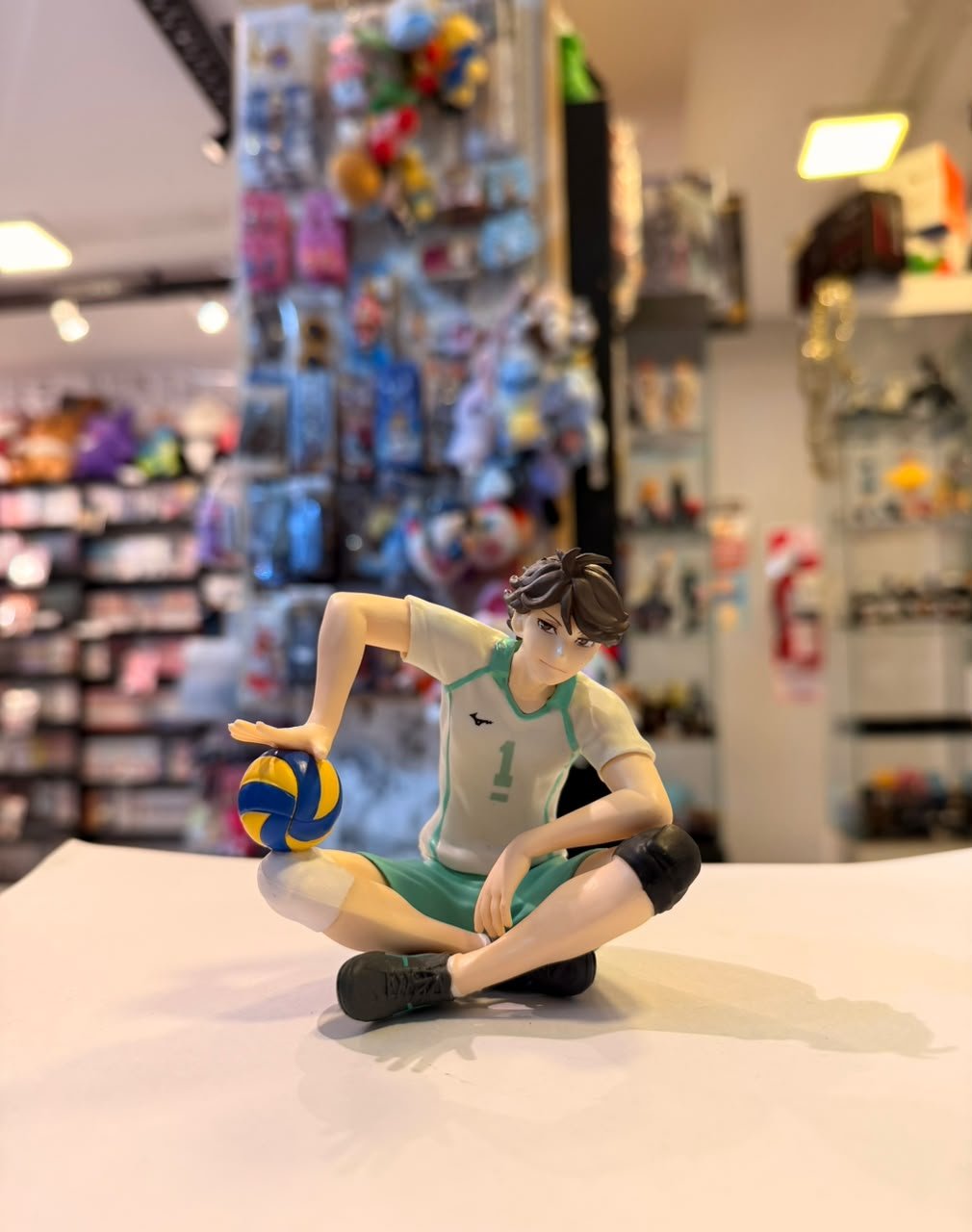 FIGURA DE TORU OIKAWA SENTADO SOSTENIENDO UN BALON