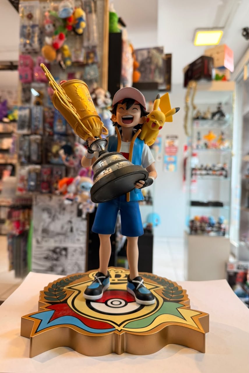 FIGURA DE ASH KETCHUM SOSTENIENDO EL TROFEO DE CAMPEON