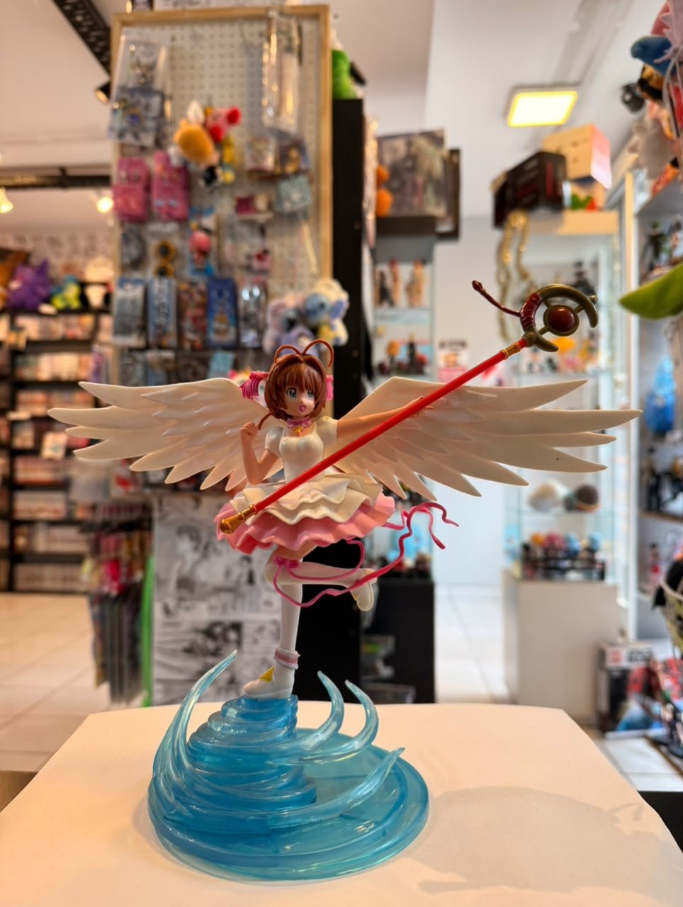 FIGURA DE SAKURA CON ALAS BLANCAS Y SU BACULO