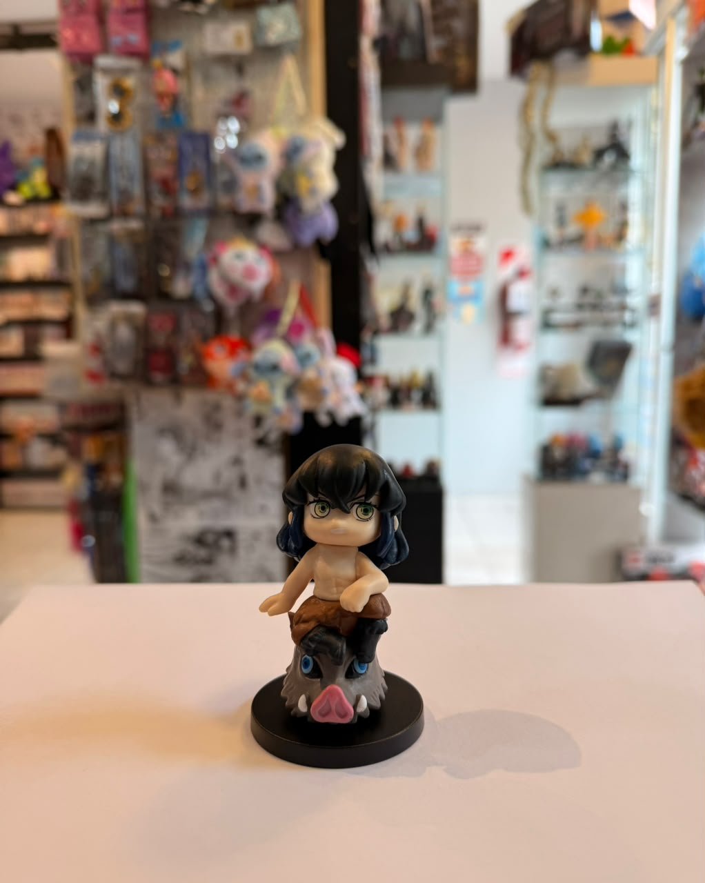 FIGURA DE INOSUKE SENTADO SOBRE SU MASCARA DE JABALI