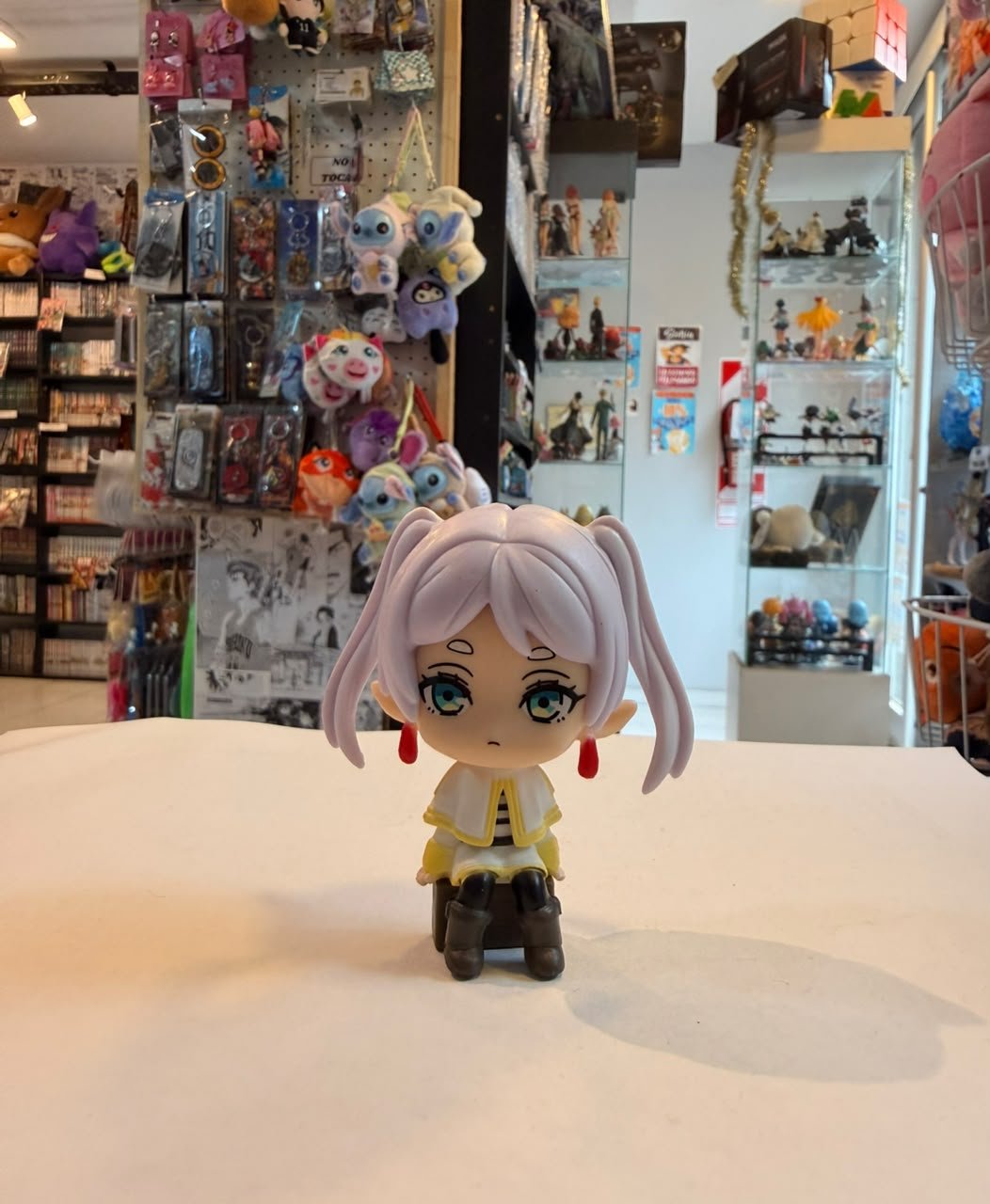 FIGURA CHIBI DE FRIEREN SENTADA SOBRE CAJON