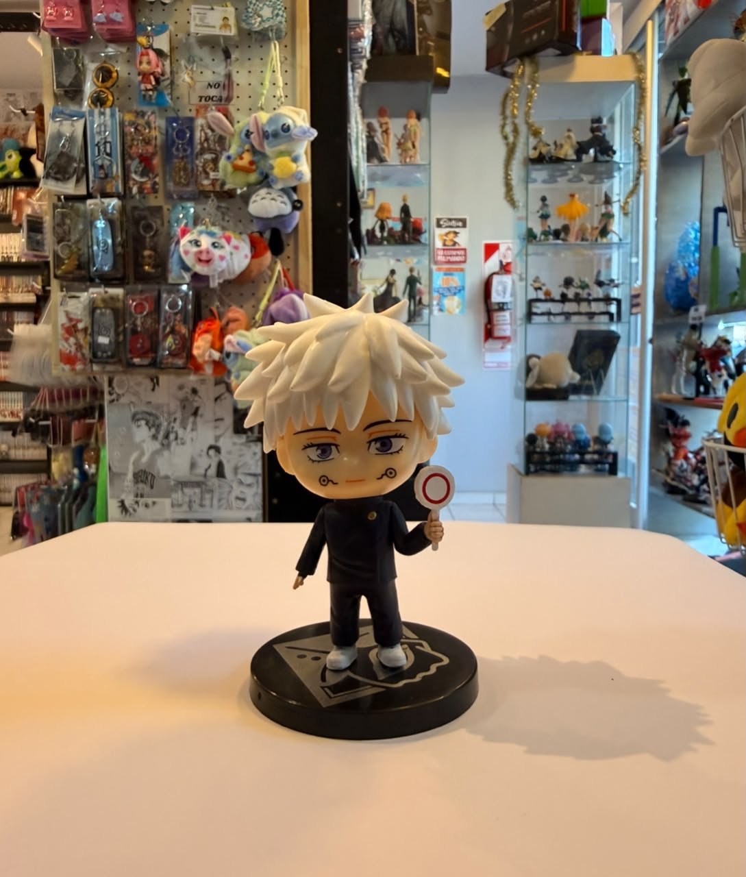 FIGURA CHIBI DE GOJO SUJETANDO UN CARTELITO CON SIMBOLO JAPONES